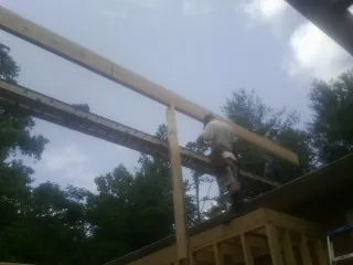 Carpenter setting a ridge beam over a new addition frame — Ice Dam Removal by Roofing Brothers in Amelia