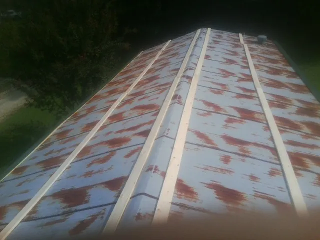 Rusted metal roof panels with new wood purlins before replacement — Storm Damage Roof Repair in Amelia by Roofing Brothers