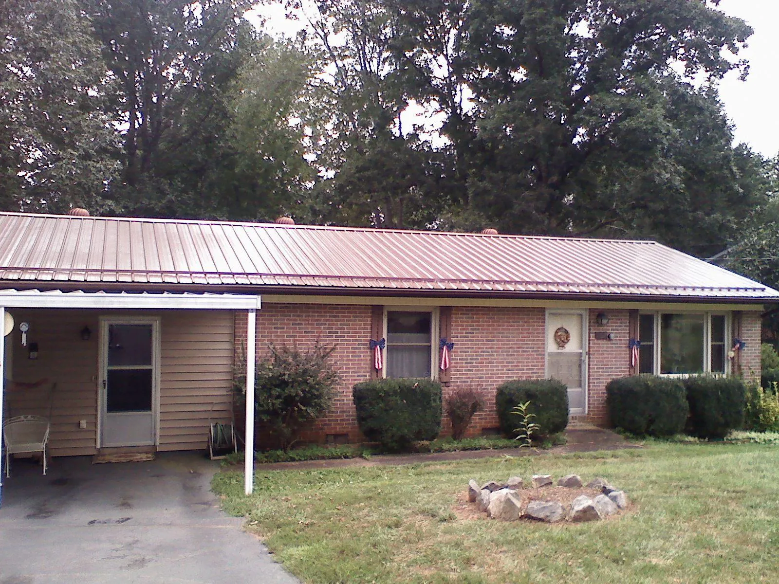Bronze metal roof and carport on a brick ranch home — Roof Repair work by our crew in Amelia