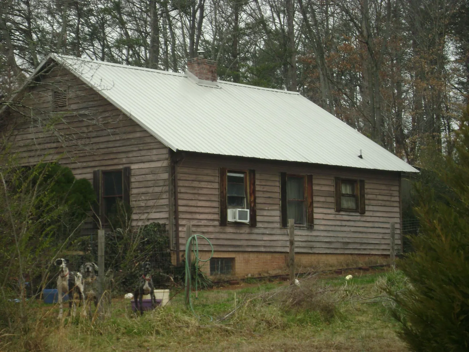 White metal roof on an old wood sided farmhouse, from a Metal Roof Installation job in Amelia